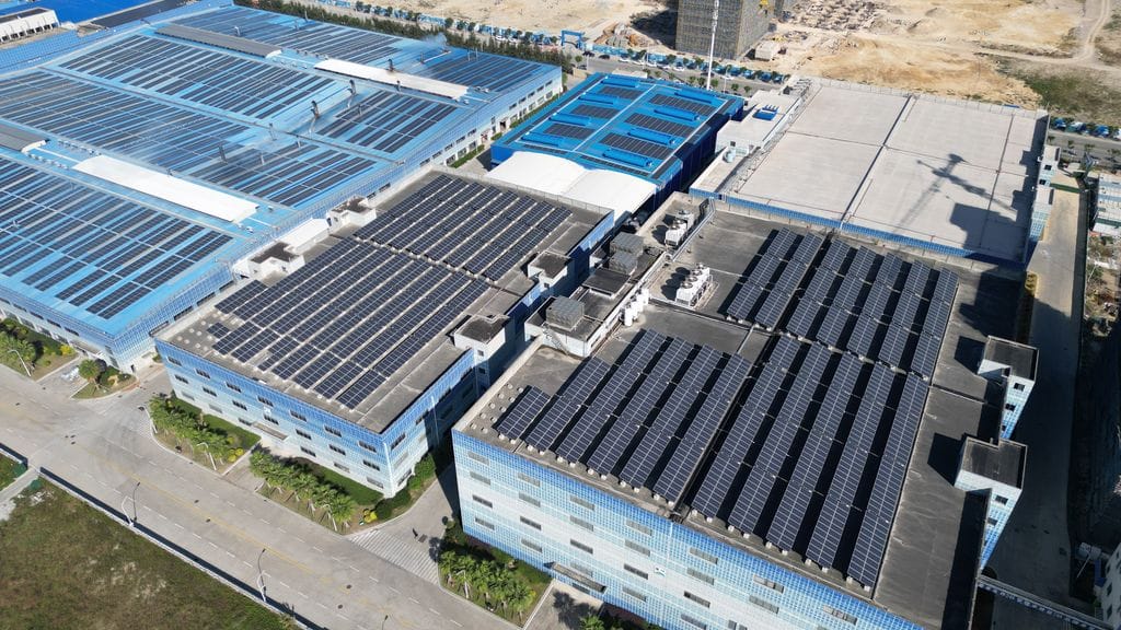 Aerial shot of industrial buildings with solar panels harnessing renewable energy.